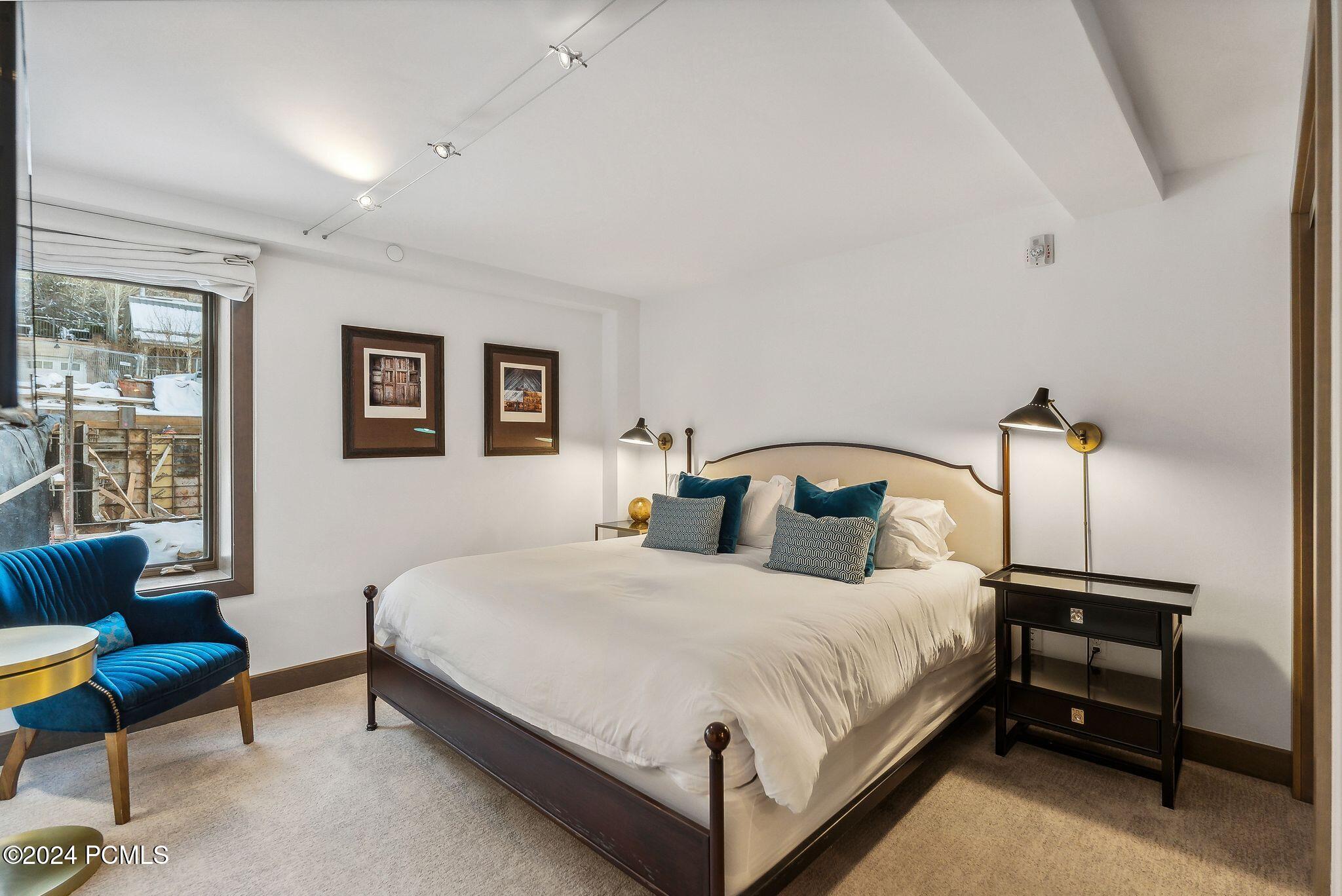 King bedroom with teal accents and modern art