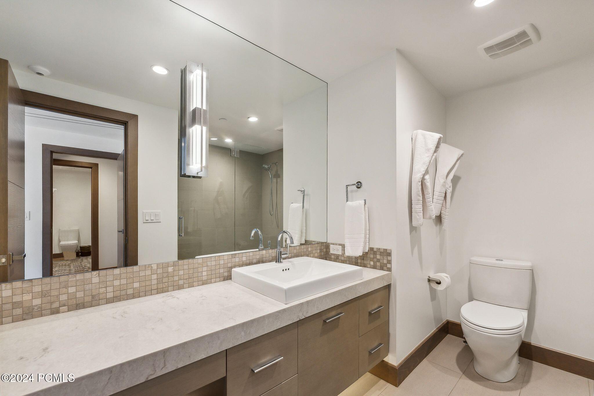 En-suite bathroom with vessel sink and glass shower