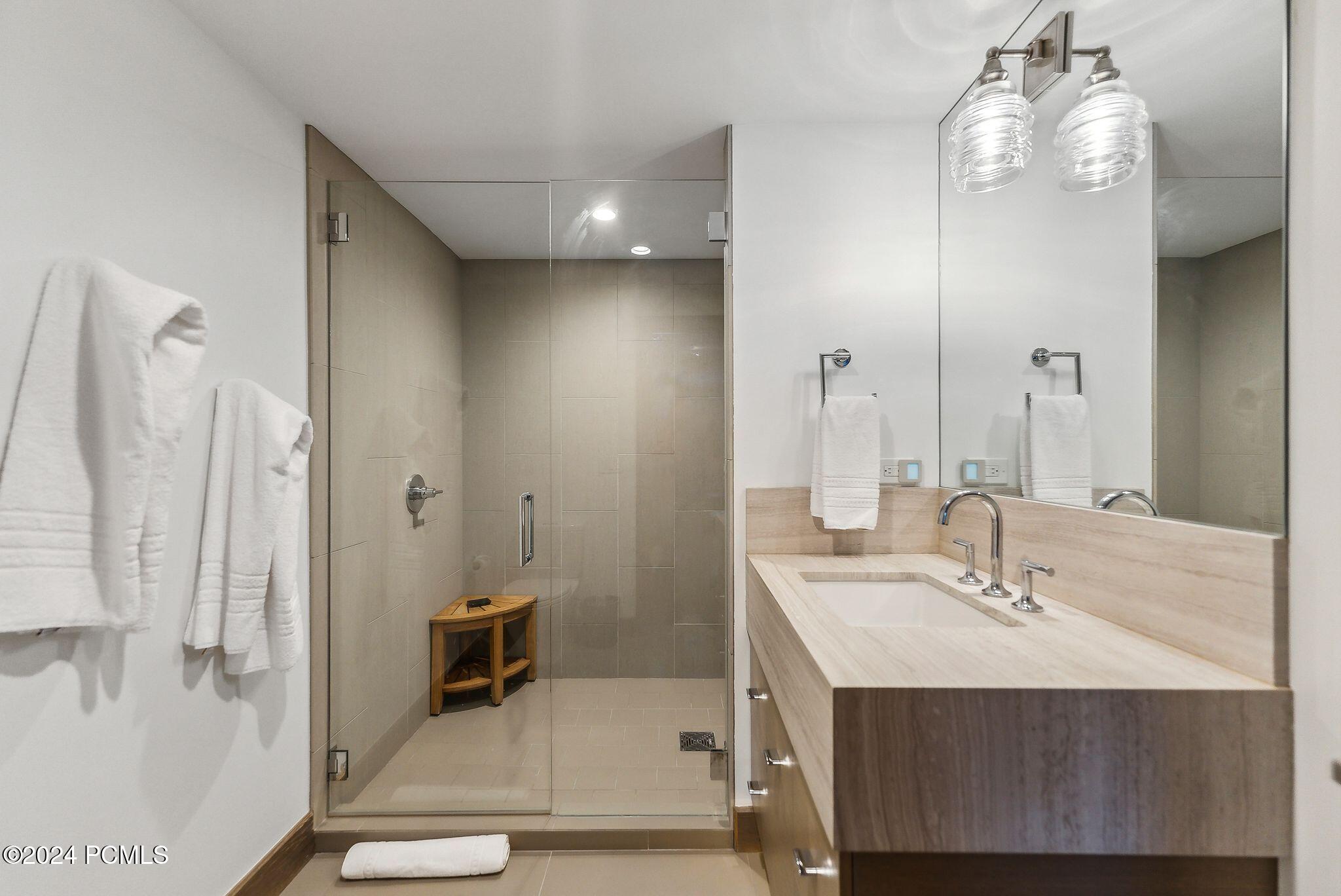 En-suite bathroom with wood vanity and teak shower bench