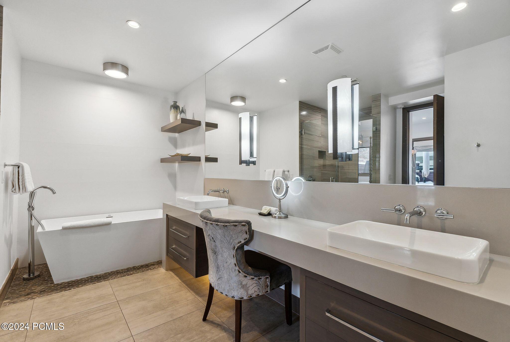Spa-like primary bathroom with soaking tub and dual vanity