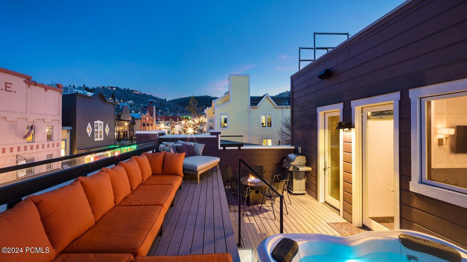 Rooftop deck with hot tub and fire pit at twilight