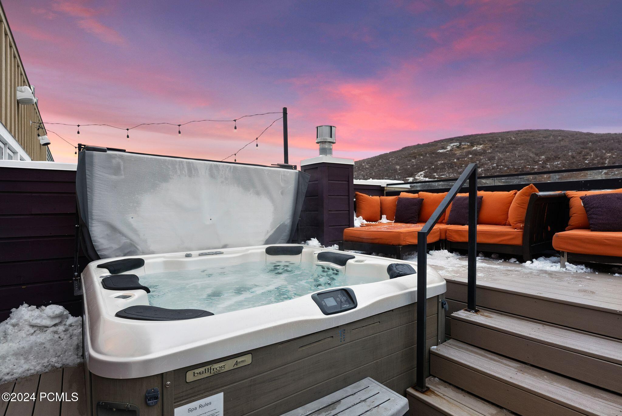 Private rooftop hot tub at sunset with mountain views