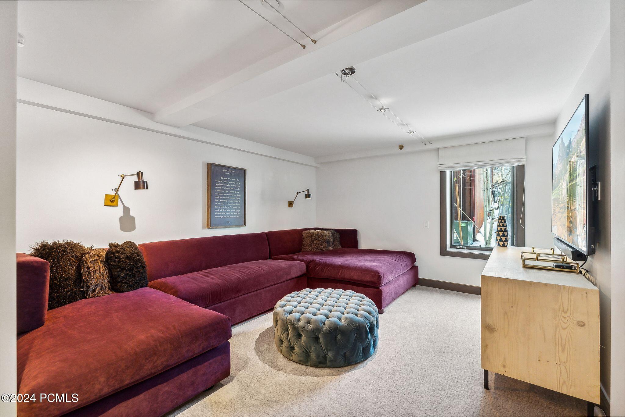 Movie room with velvet sectional sleeper and large TV