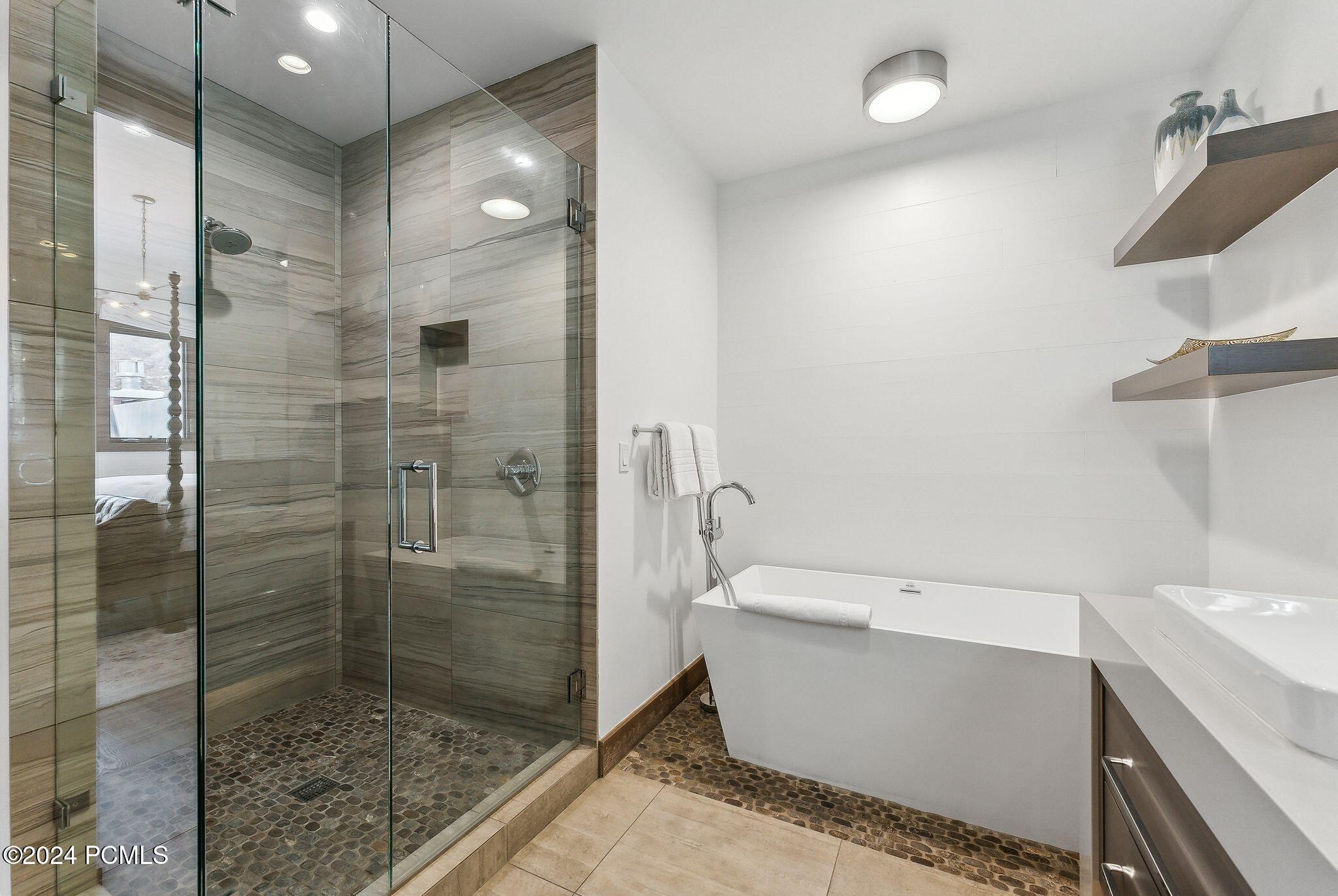 Glass walk-in shower and freestanding soaking tub